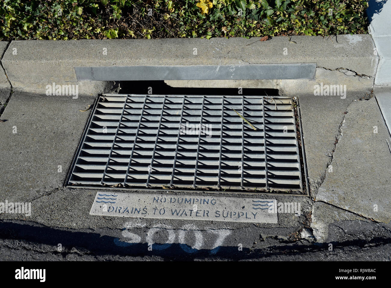 street drain sign saying no dumping, drains into the water supply, in San Francisco East Bay, California Stock Photo