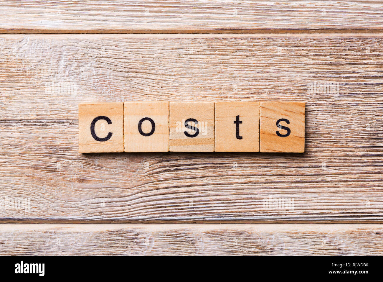 costs word written on wood block. costs text on wooden table for your
