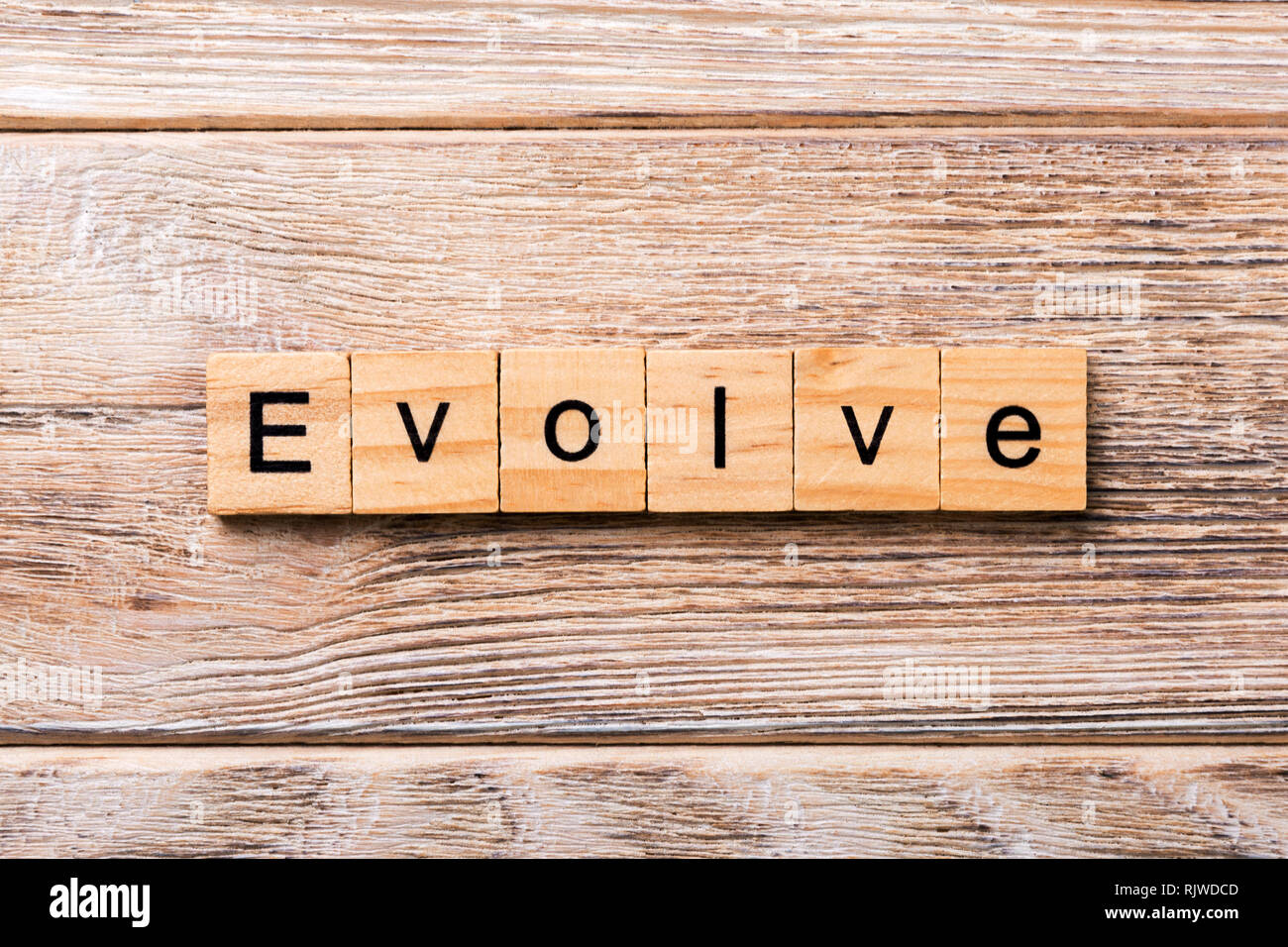 EVOLVE word written on wood block. EVOLVE text on wooden table for your desing, concept. Stock Photo