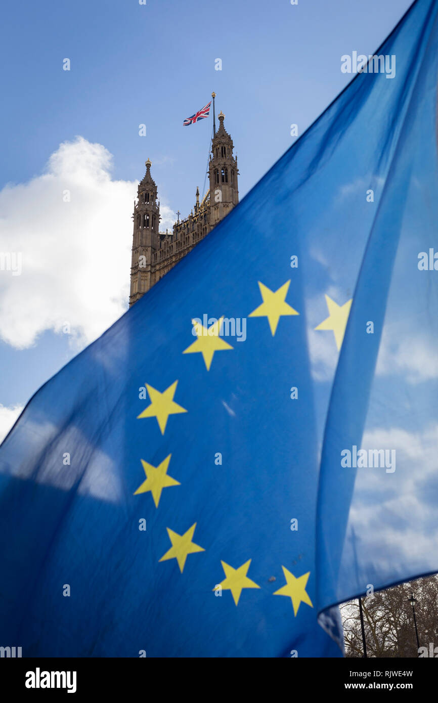 As Prime Minister Theresa May negotiates further Britain's exit from the European Union in Brussels, the UK parliament is seen through the yellow stars of the EU flag, flying as part of an anti-Brexit protest opposite the Houses of Parliament, on 7th February 2019, in Westminster, London England. Stock Photo
