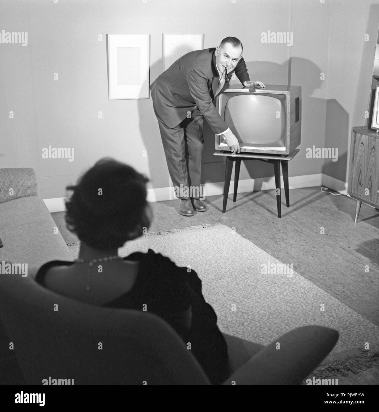 Television in the 1950s. A proud elderly man is pictured in his home with his wife with the latest in electronic home equipment visible. A typical television set on thin legs.  Photo Kristoffersson ref CD89-9. Sweden 1959 Stock Photo