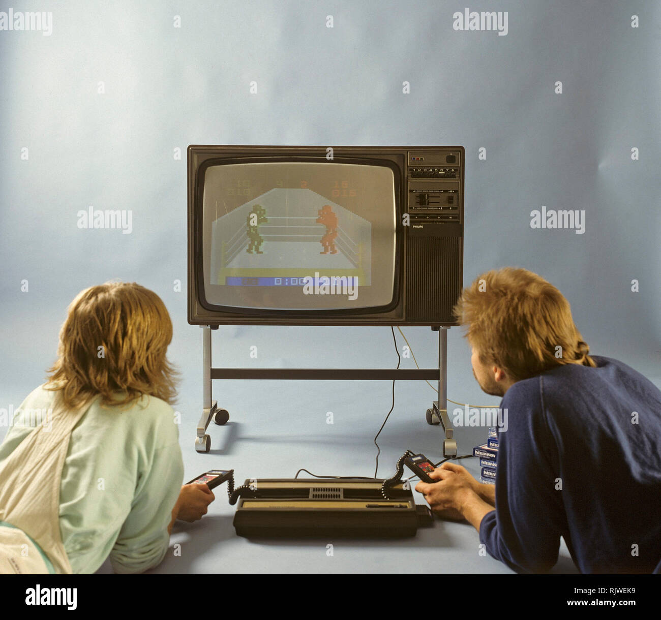 Home video games in the 1980s. A home video game console from Intellivison released by Mattel electronics in 1979. Pictured two people playing a boxing game on a television set. Stock Photo