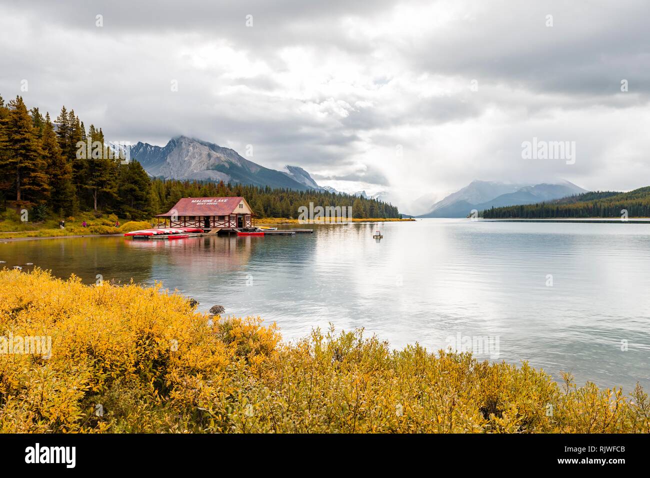Curly Phillips Boathouse, historic boathouse on the lakeshore of Maligne Lake, Queen Elizabeth Ranges mountain chain behind Stock Photo