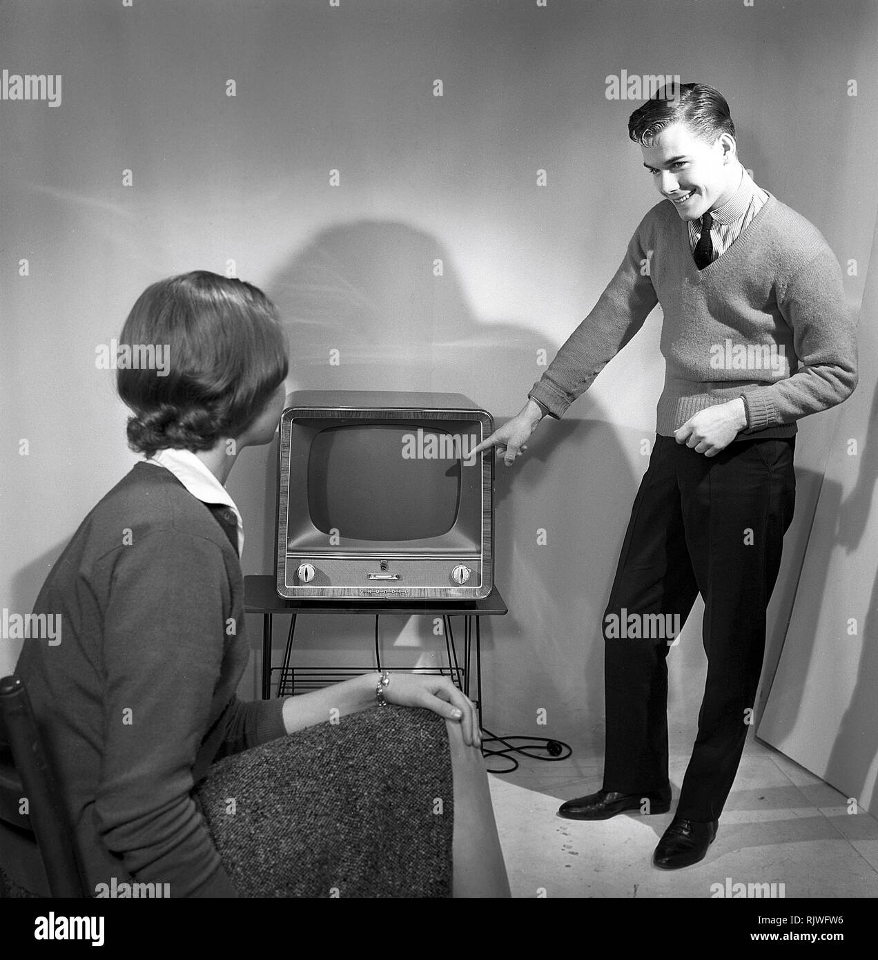 Television in the 1950s. A young couple is pictured with a typical 50s television set.  Photo Kristoffersson ref CC94-4. Sweden 1958 Stock Photo