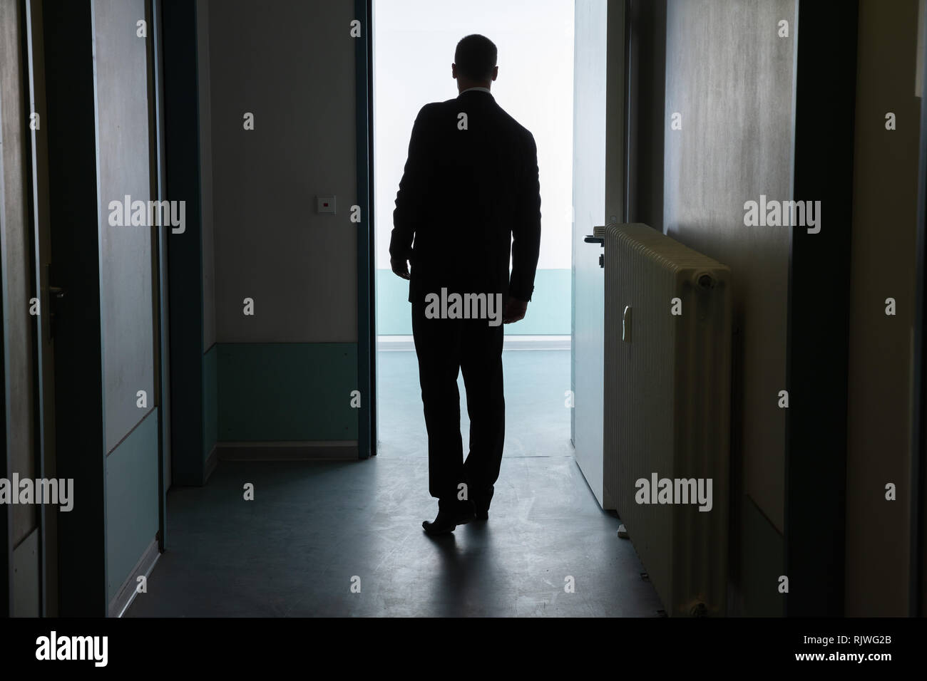Rear View Of A Businessman Standing In Front Of Open Door Stock Photo