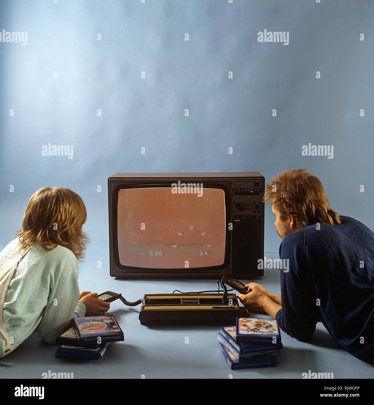 Home video games in the 1980s. A home video game console from Intellivison released by Mattel electronics in 1979. Pictured two people playing a game on a television set. ref BV97-5 Stock Photo