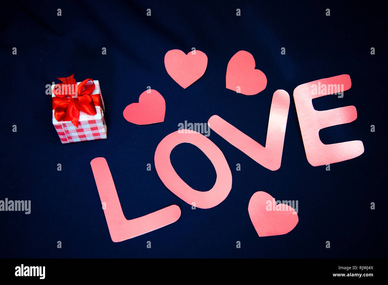 The word love written in pink on a black background photo – Free