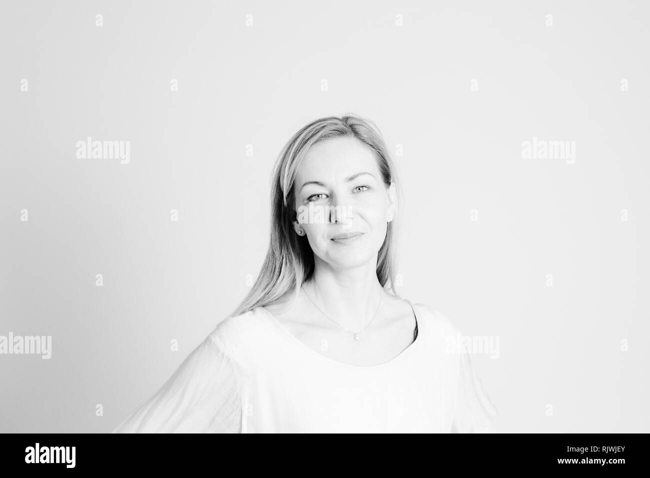 Close up portrait of beautiful woman in a white dress against white ...
