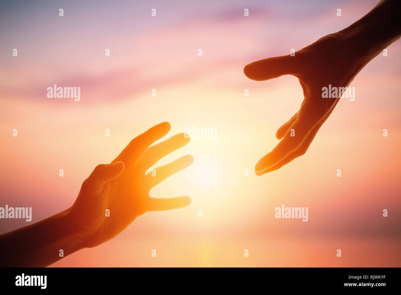 Giving a helping hand on the background of the dawn Stock Photo