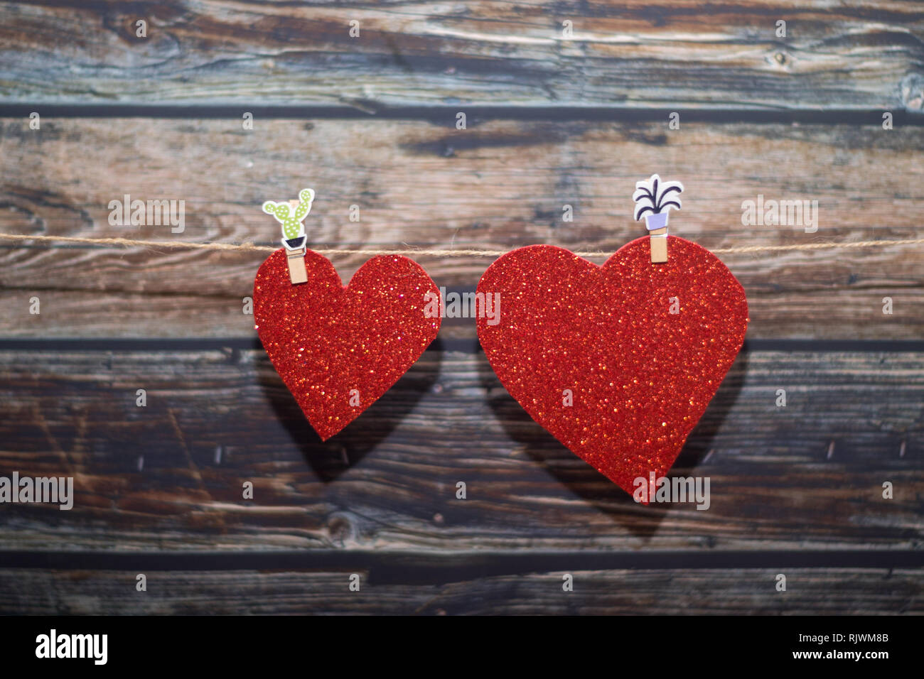 beautiful hearts hanging from a pair of tweezers Stock Photo