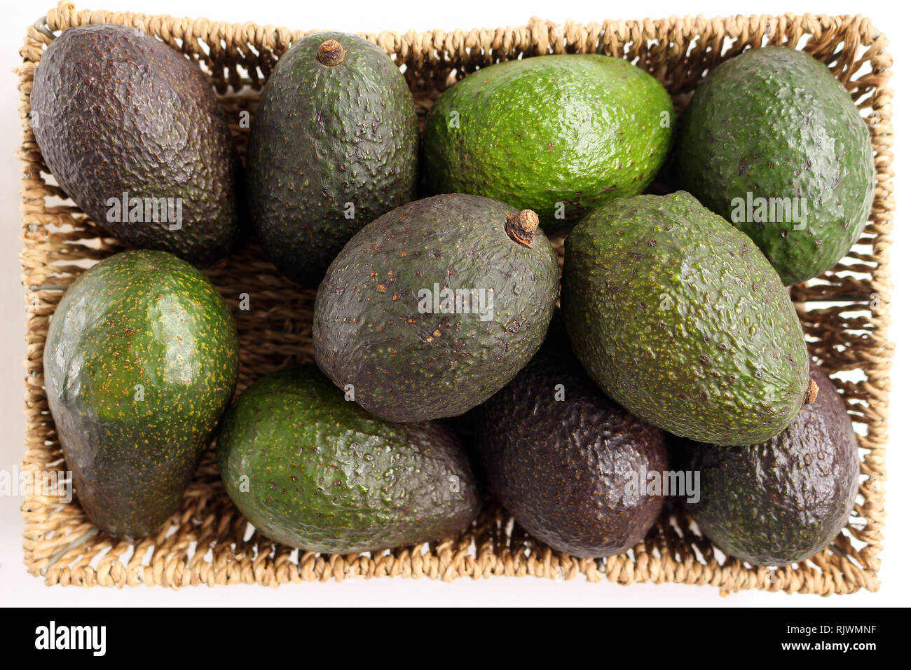 Overhead shot of four green avocados in a rectangular shaped straw fruit  basket Stock Photo - Alamy