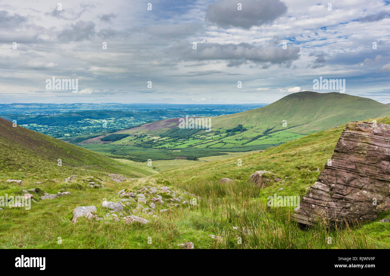 View towards Glen of Aherlow from the Galty Mountains, County Tipperary, Ireland, with large boulder of pebbly Devonian red sandstone in foreground Stock Photo