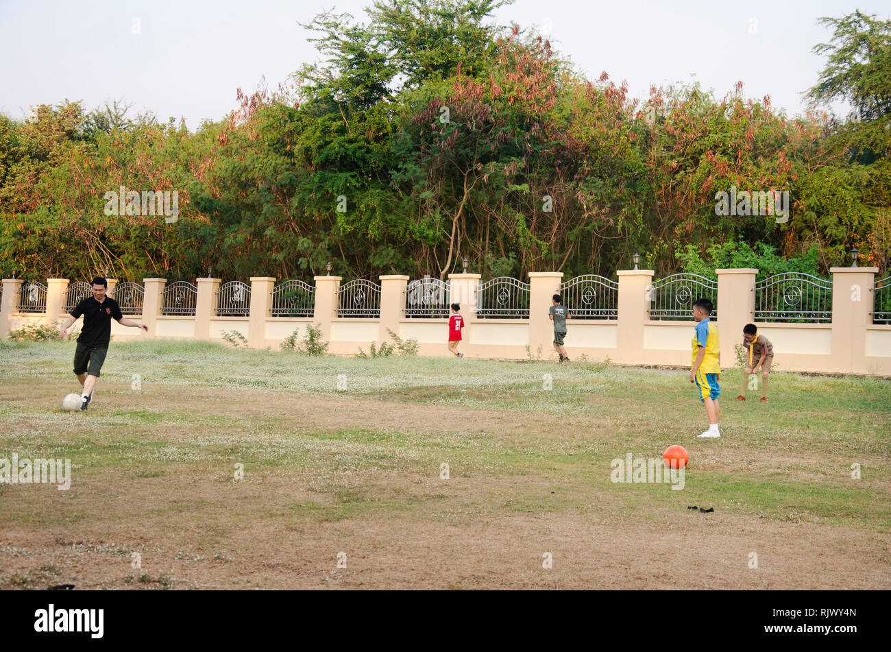 Asian Thai Father Training And Playing Football Or Soccer With Son