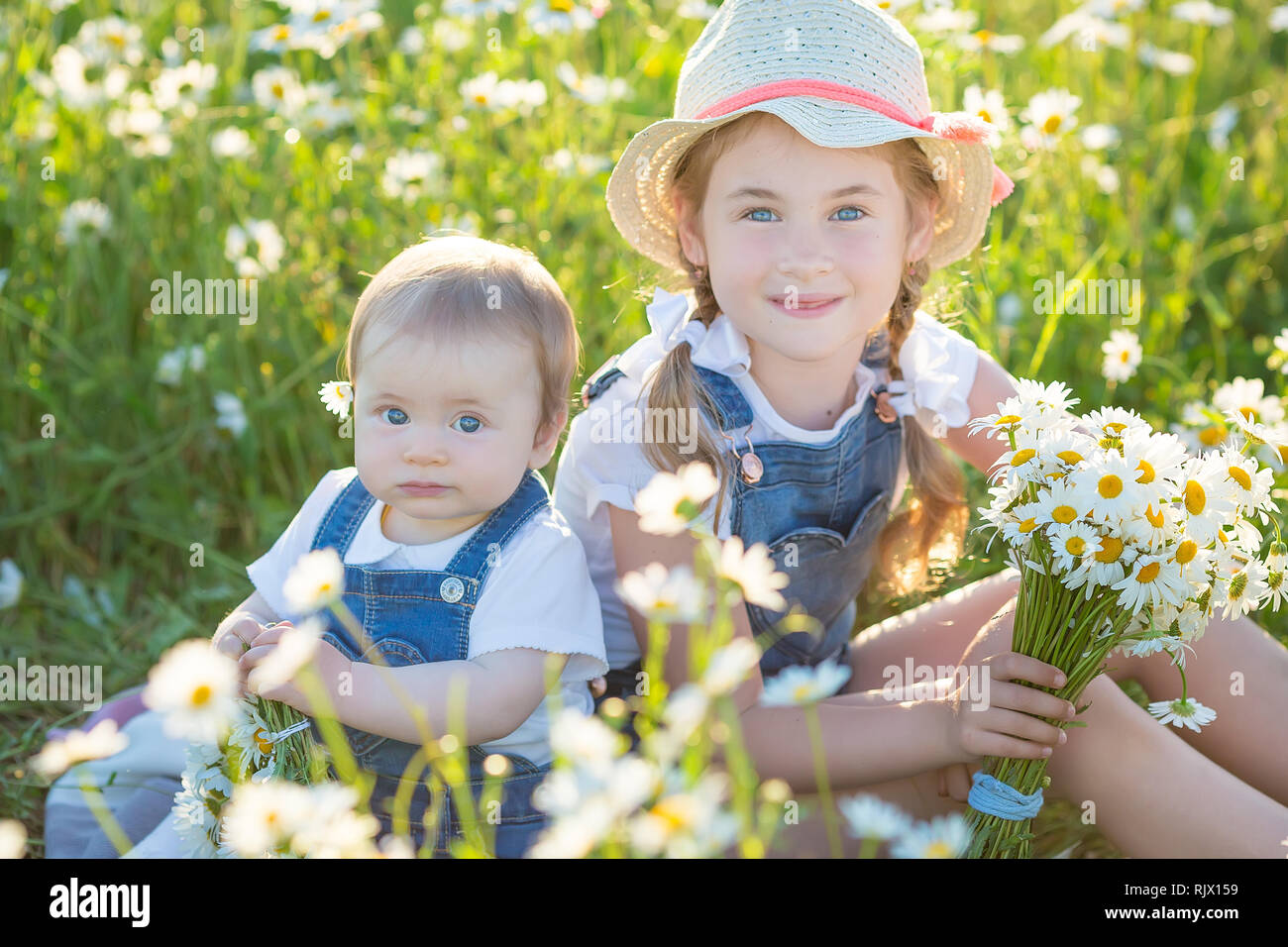 Little girl in a field with flowers Stock Photo - Alamy
