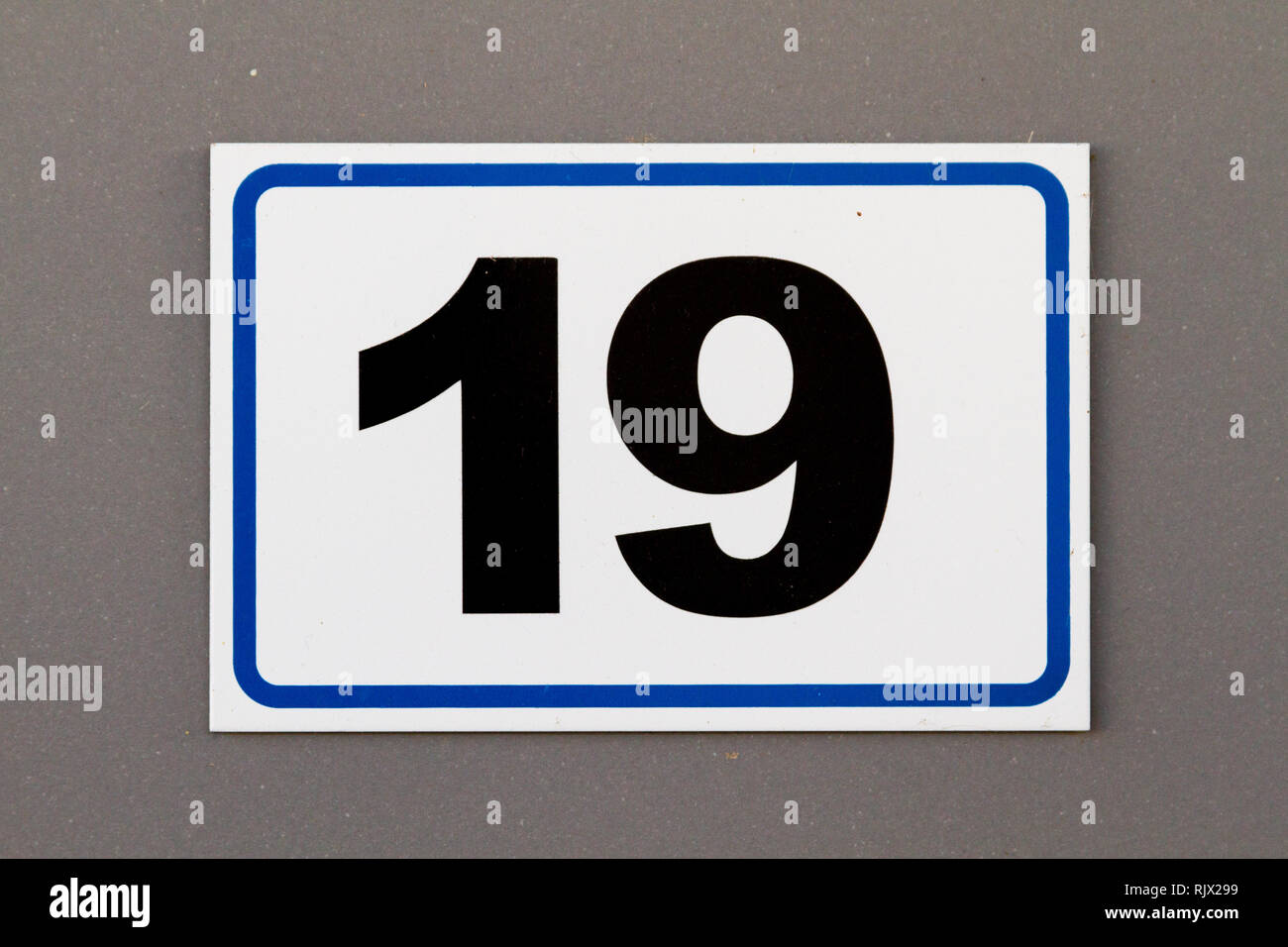 Number 19 (nineteen) in black on a white platic plate on a house Stock Photo