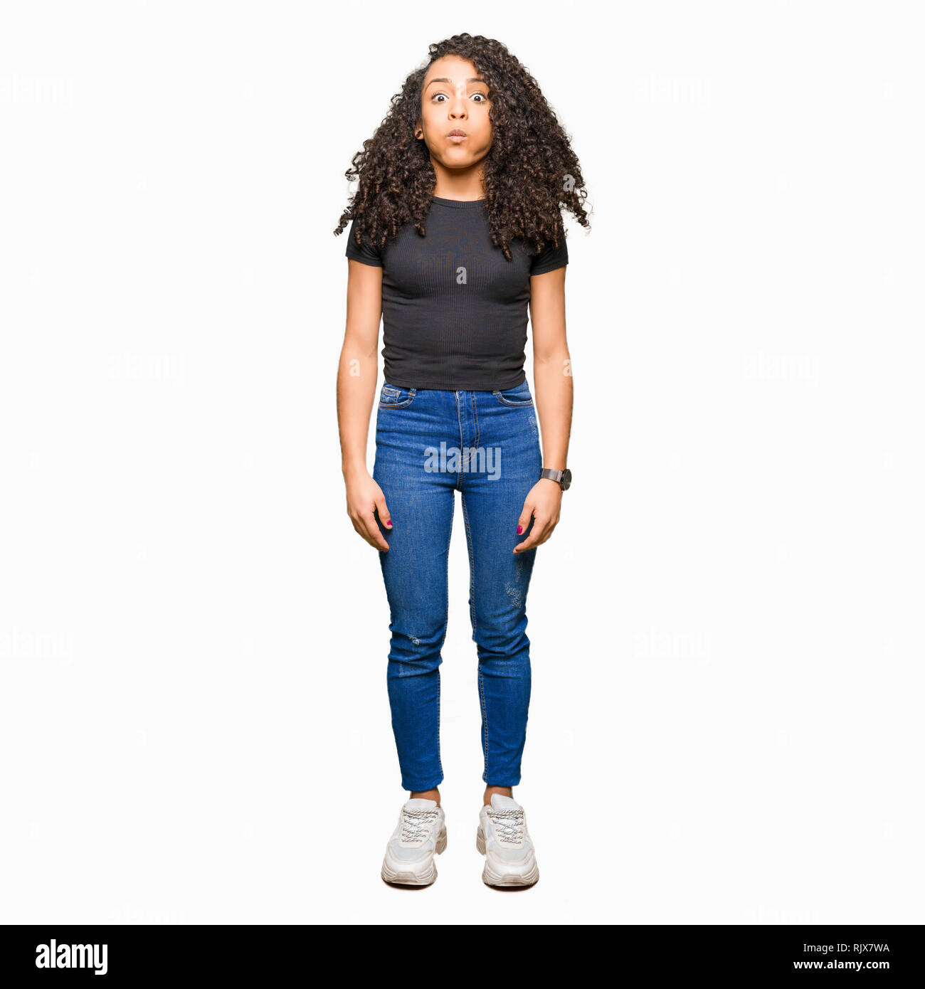 Puffing Cheeks Young beautiful woman with curly hair puffing cheeks with funny face ...