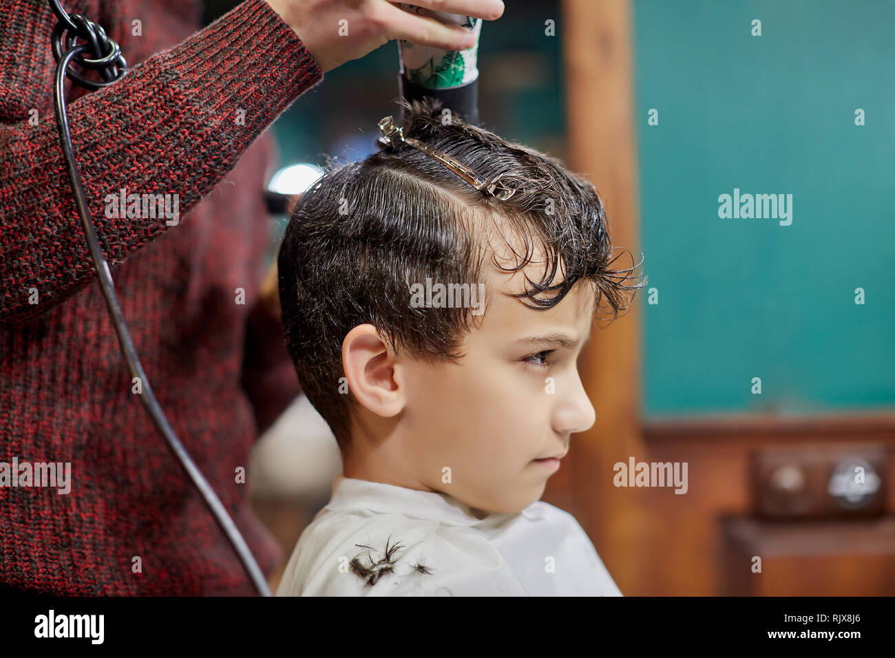 Crop Stylist Making Haircut To Serious Boy Stock Photo 235376126
