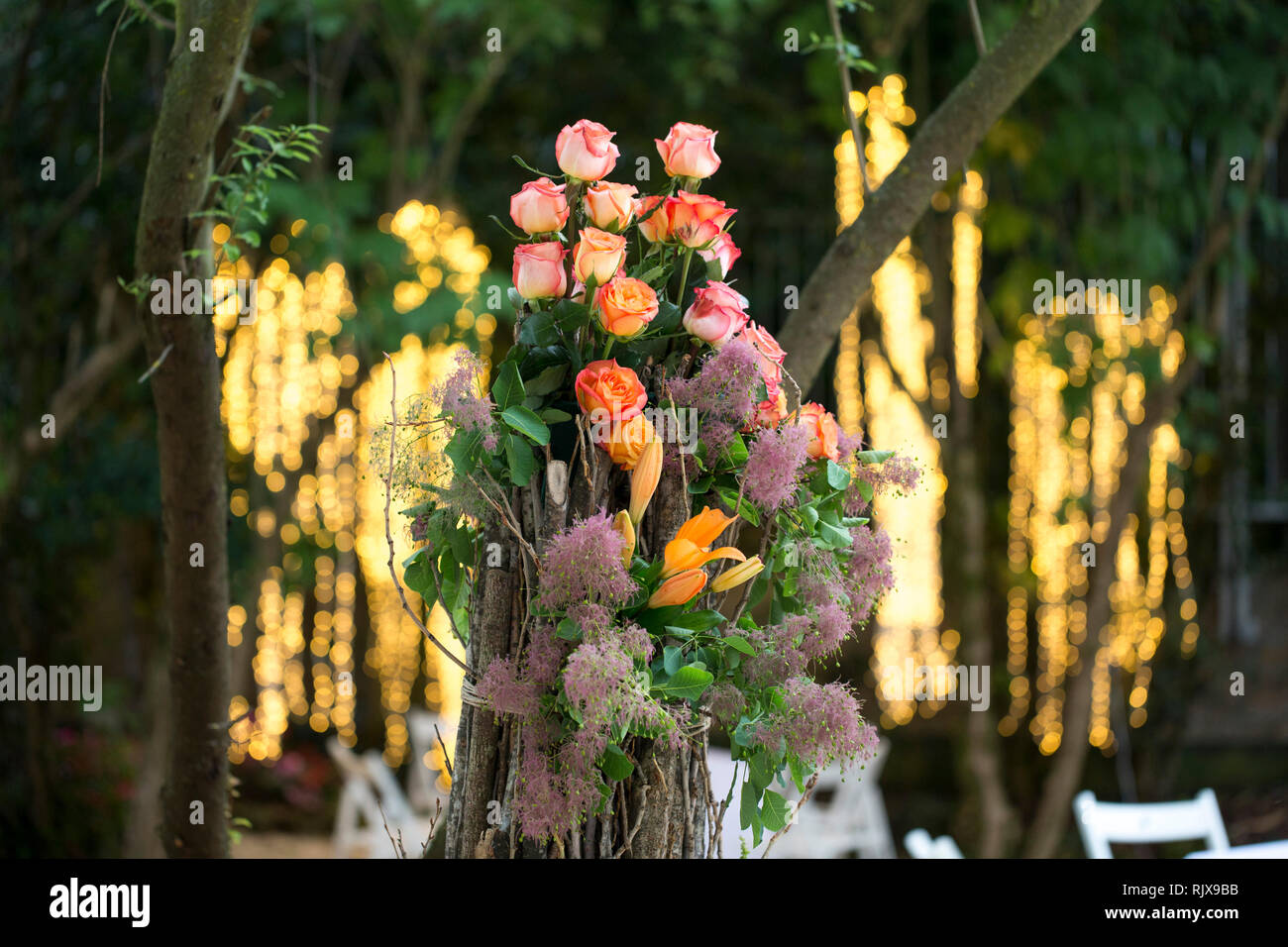 closeup of a spring wedding party, flower centerpiece with a cascade of lights  behind the table. Stock Photo