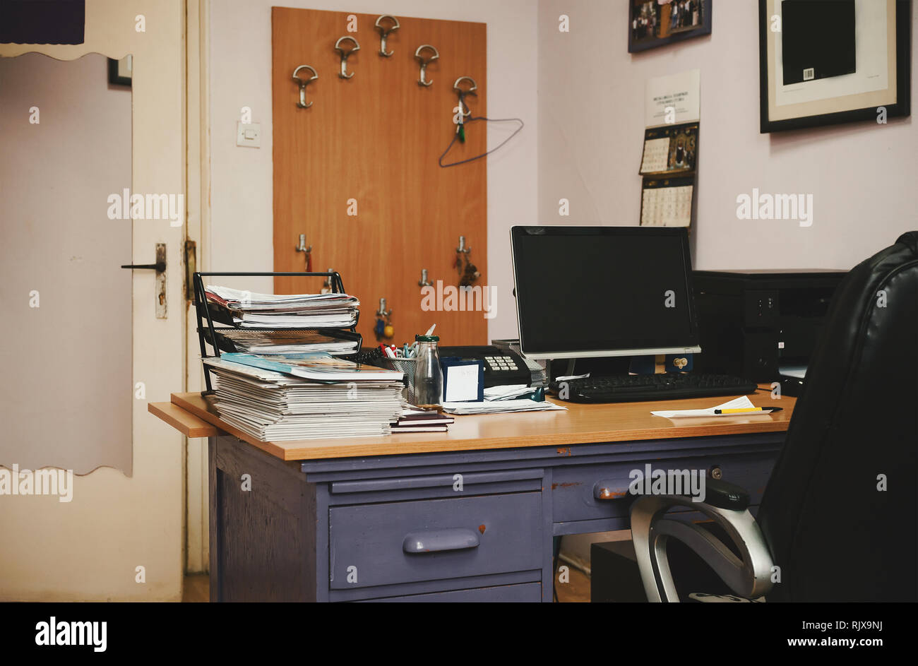 Old messy office, furniture details, closeup view on table full of papers and various working materials. Stock Photo