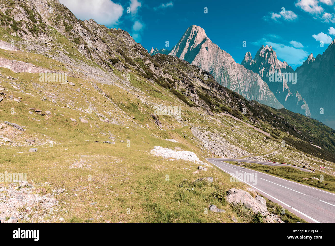 road through mountains with rocky cliff. summer travel concept. composite image with creative toning Stock Photo