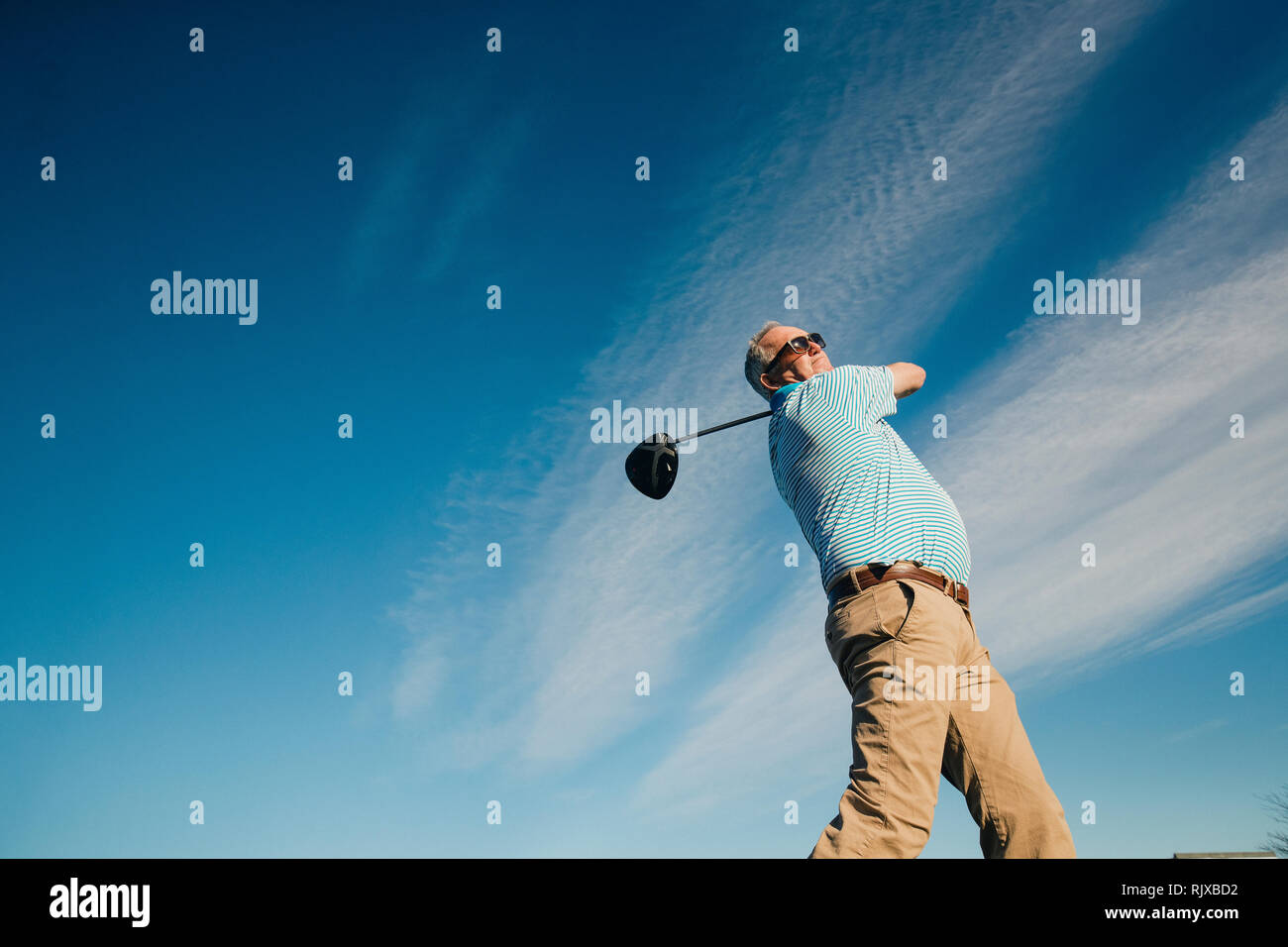 Ball perspective shot of a senior man swinging a golf club. Stock Photo