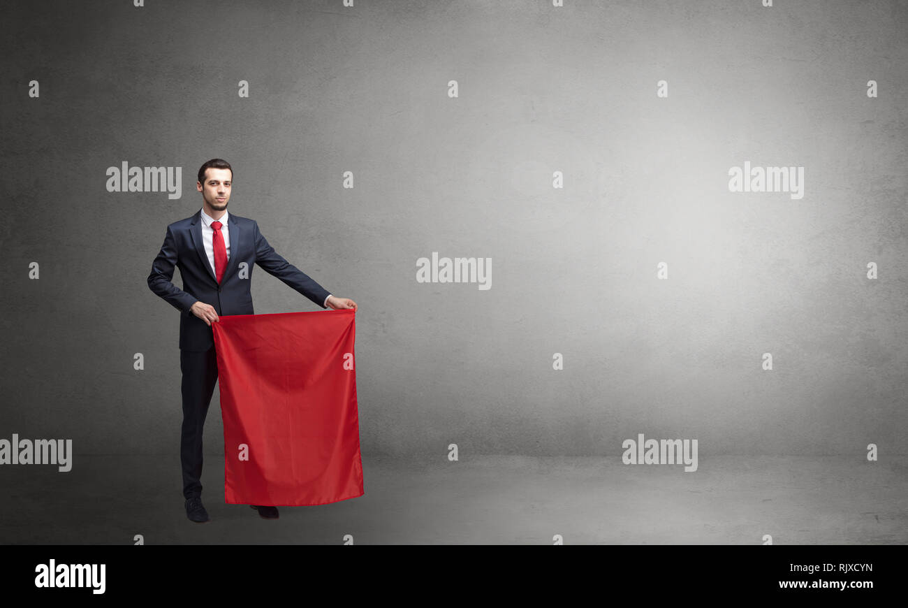 Businessman standing with red toreador cloth in his hand in an empty room  Stock Photo