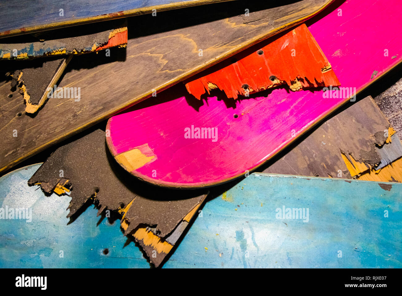 Broken colourful skateboard decks stacked on top of each other