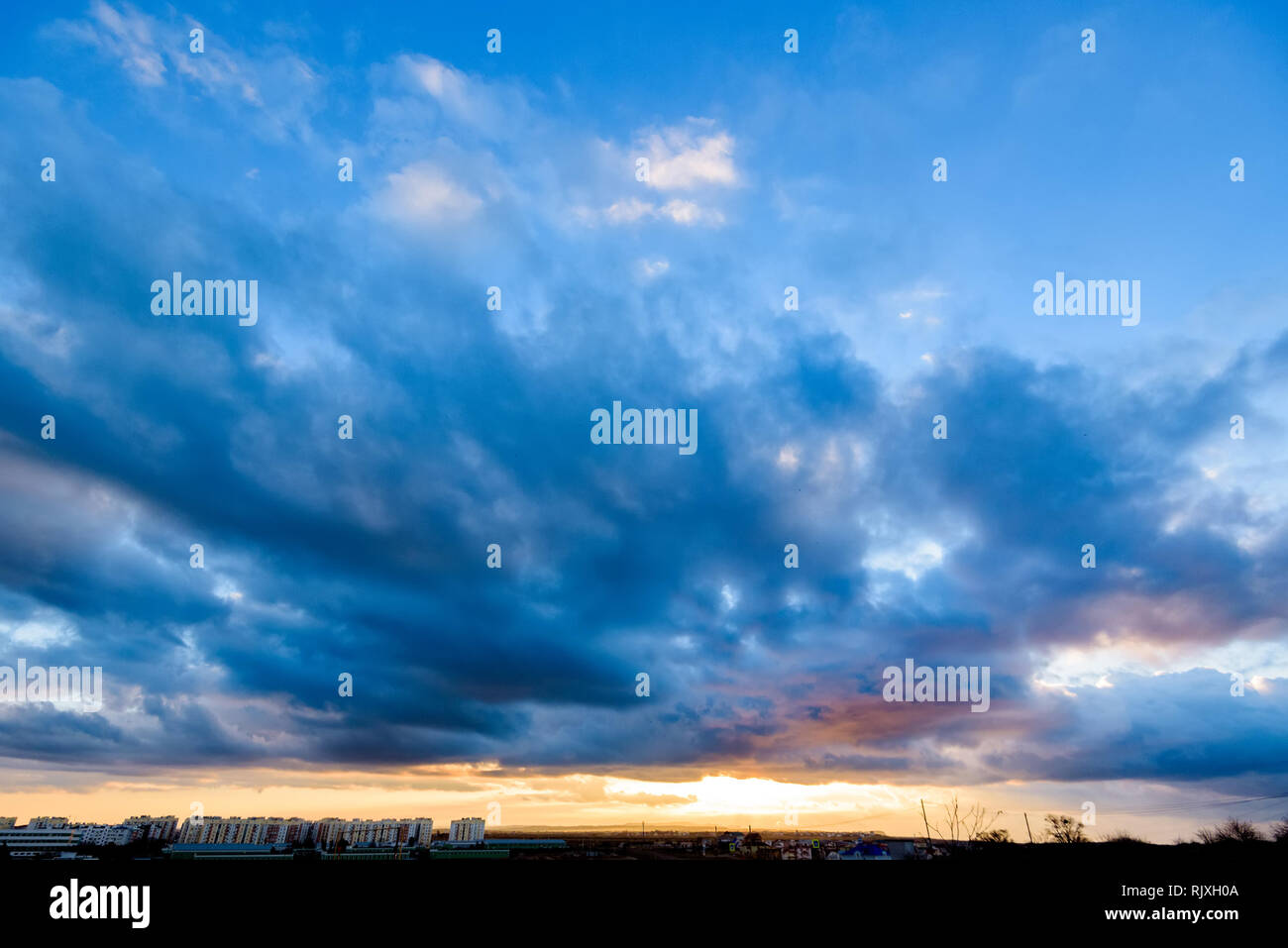 Dramatic sky over modern city in distance Stock Photo - Alamy