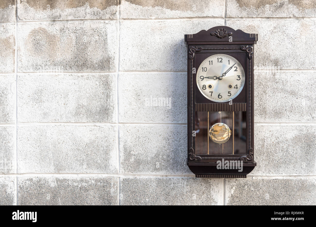 Antique wall clock with a pendulum Stock Photo