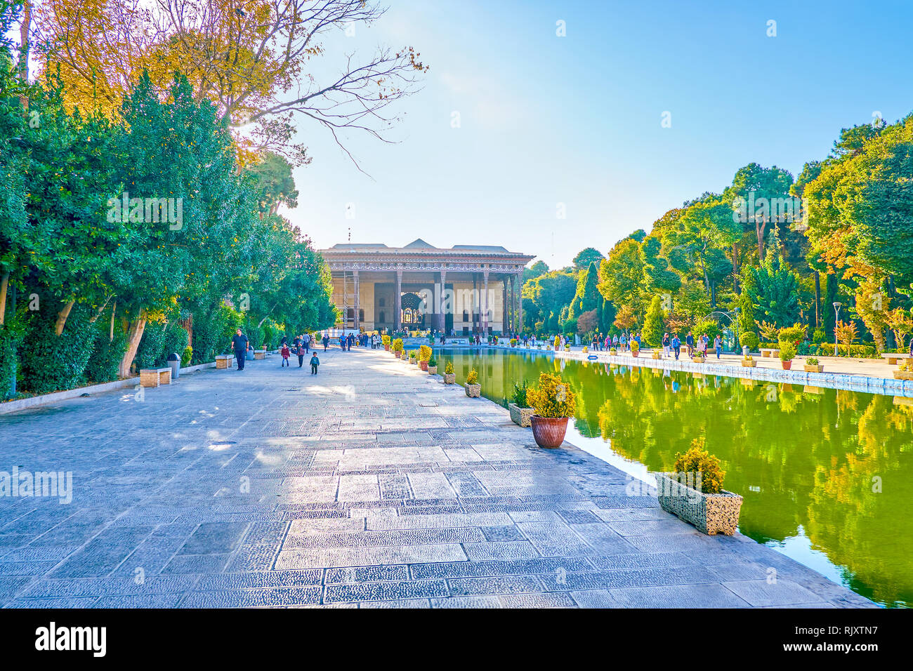 ISFAHAN, IRAN - OCTOBER 19, 2017: The way to  Chehel Sotoun Palace along lush garden and large pool, on October 19 in Isfahan Stock Photo