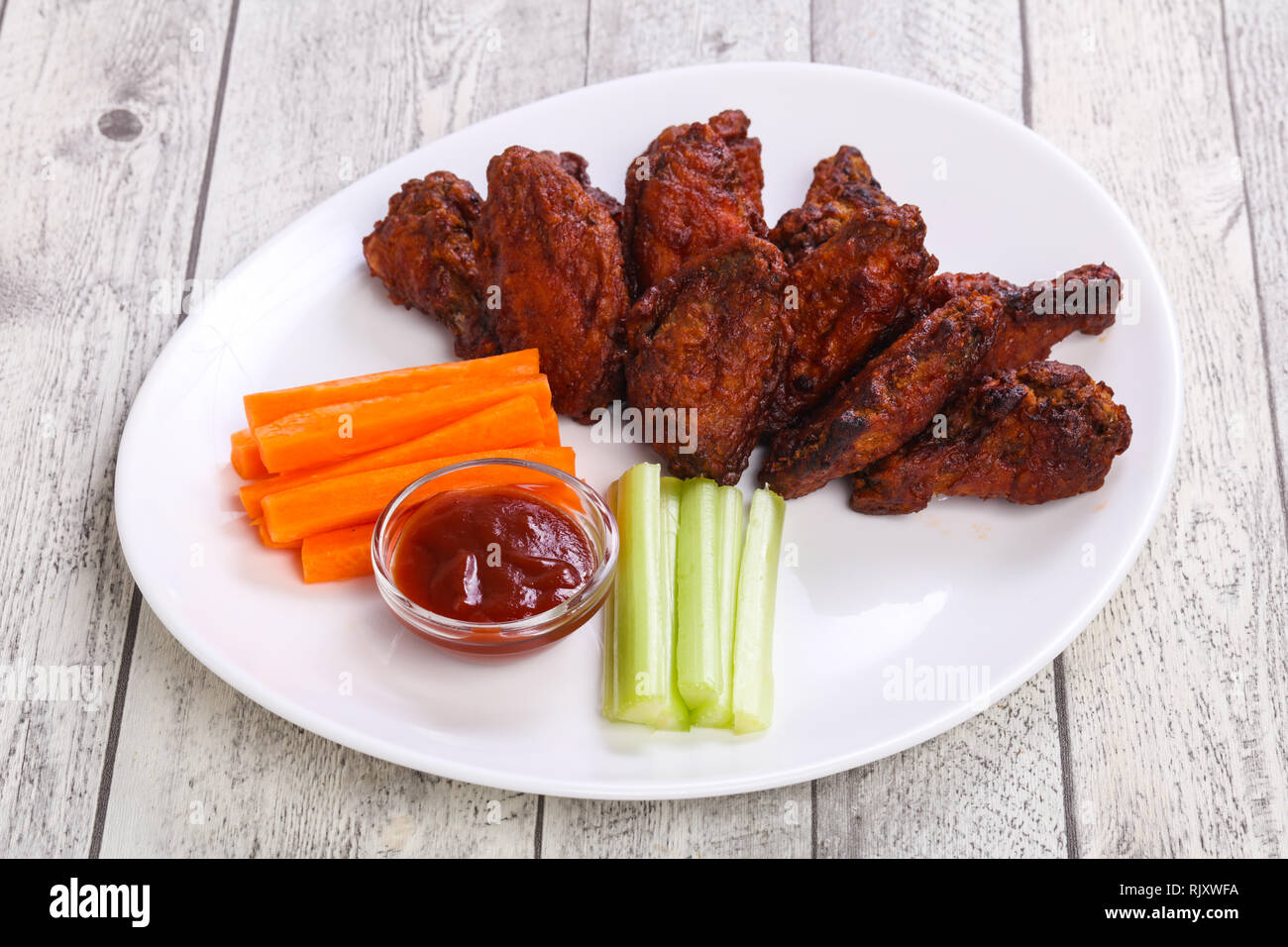 Chicken wings bbq with celery and carrot sticks Stock Photo Alamy