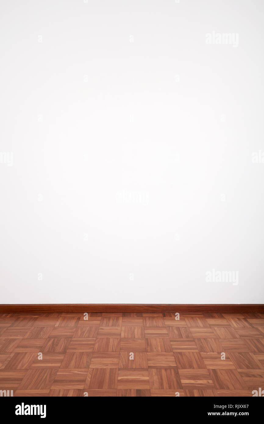 Room with brown wooden tiled floor and white blank wall Stock Photo