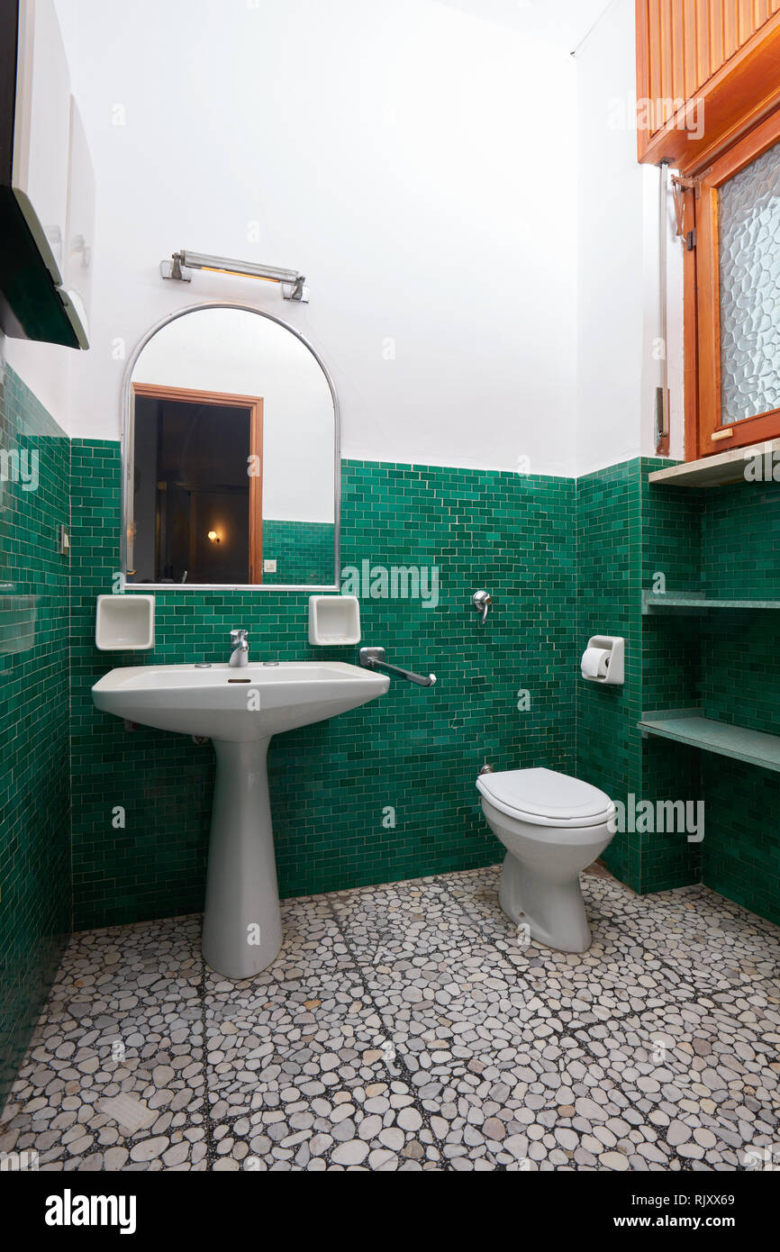 Old bathroom with green tiles in apartment interior Stock Photo