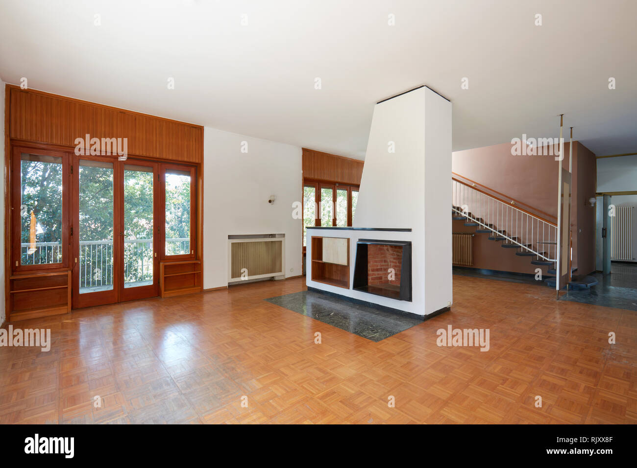 Empty living room with fireplace, apartment interior in old house with garden Stock Photo