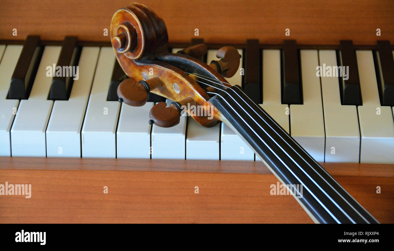 A violin lying on a piano Stock Photo