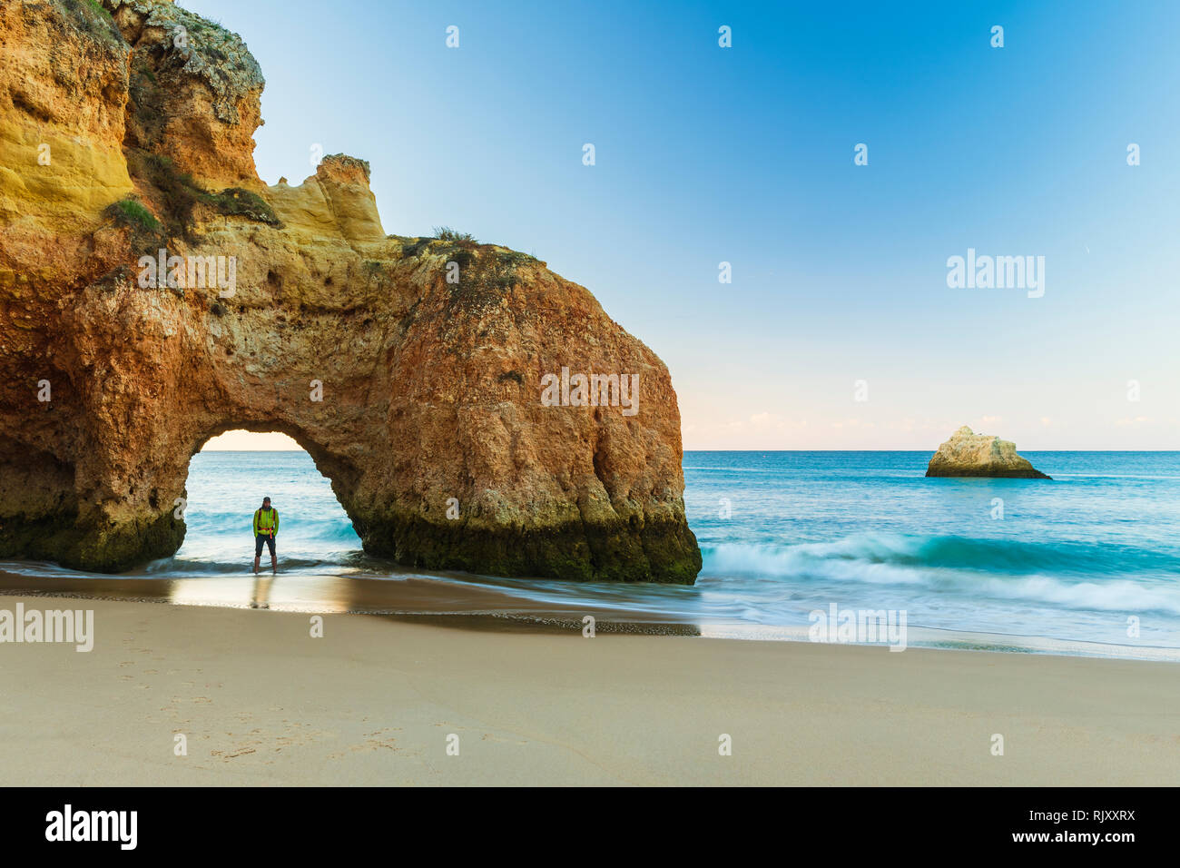 Distant view of man looking at sea view from beach, Alvor, Algarve, Portugal, Europe Stock Photo