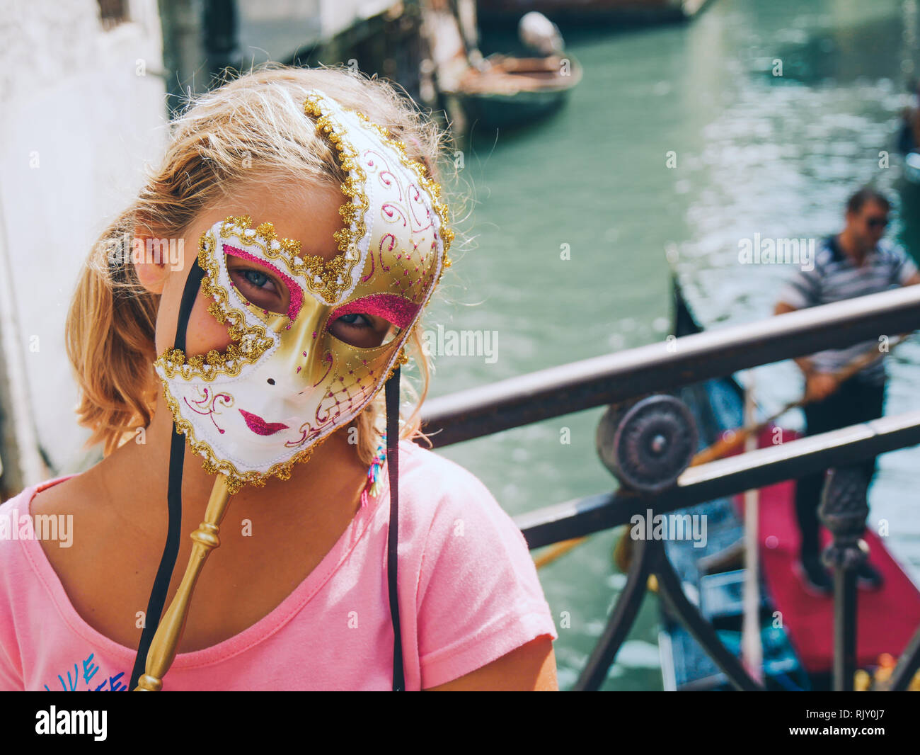 LIttle girl with blue eyes and carnival mask. Carnival in Venice, Italy. Stock Photo