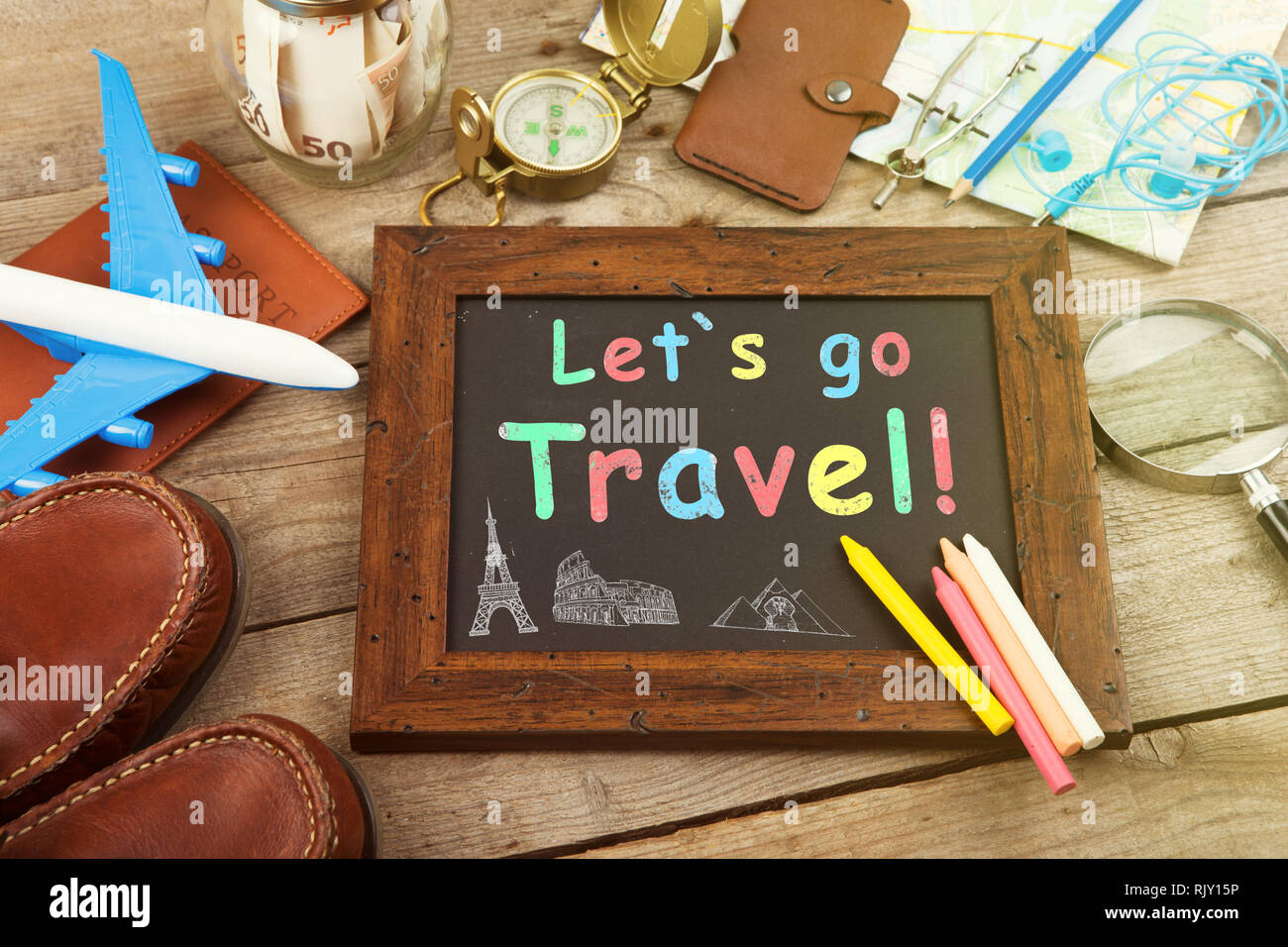 https://c8.alamy.com/comp/RJY15P/let%60s-go-travel-inscription-on-the-blackboard-jar-with-money-for-a-travel-airplane-maps-passport-and-other-stuff-for-adventure-on-the-table-RJY15P.jpg