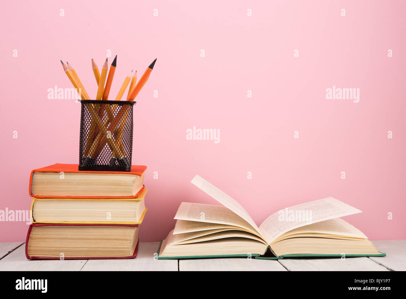 Sách mở trên bàn gỗ với nền hồng nhẹ sẽ giúp bạn cảm thấy thư thái và thăng hoa khi học tập. Hình ảnh đơn giản và đẹp mắt này sẽ giúp bạn tránh xa áp lực và đồng thời cung cấp niềm đam mê cho sự học hỏi.