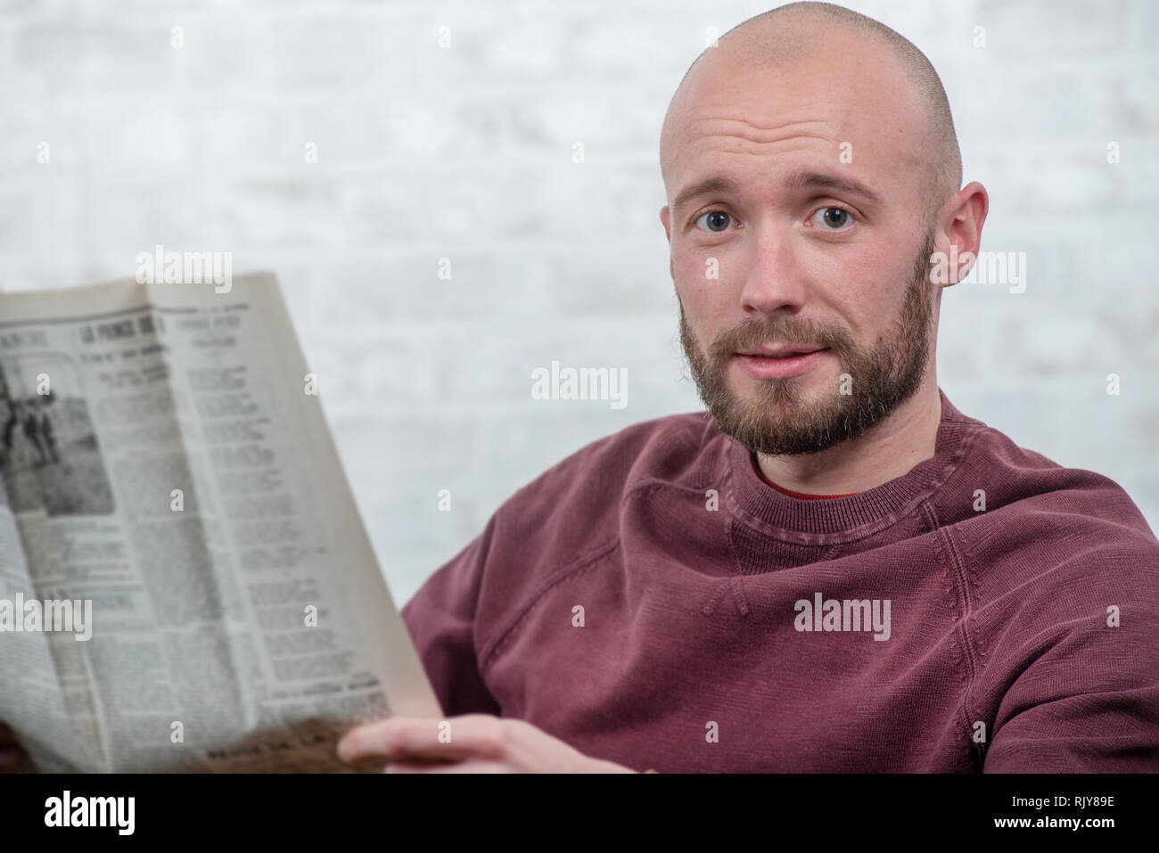young man with a beard reading the newspaper Stock Photo - Alamy