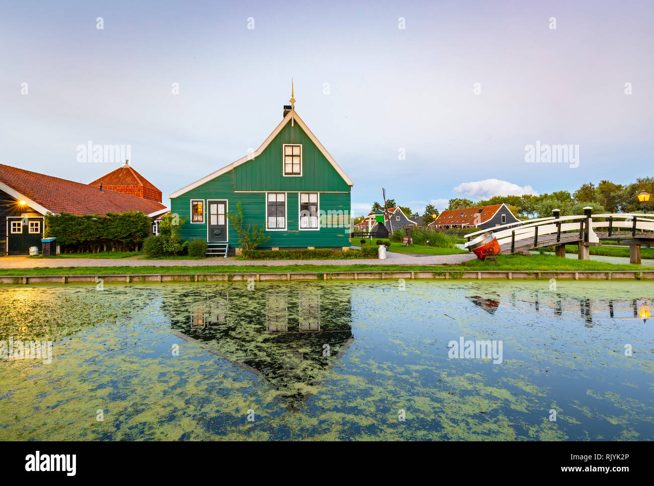 Typically traditional Dutch house, windmill, historical architecture and bridge over water at the Zaanse Schans, Popular touristic landmark. Stock Photo