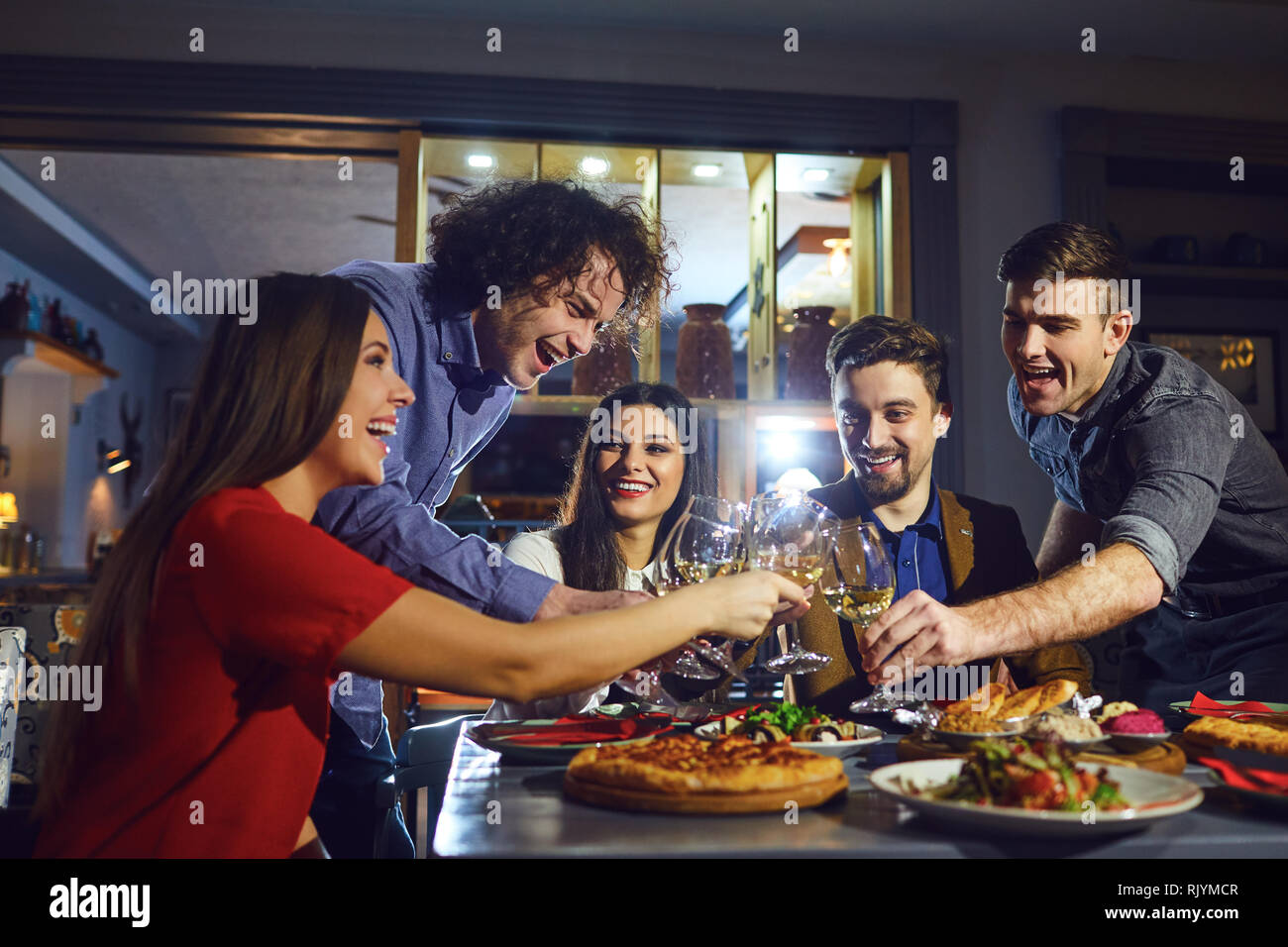 Friends in a restaurant with glasses of wine in the evening. Stock Photo