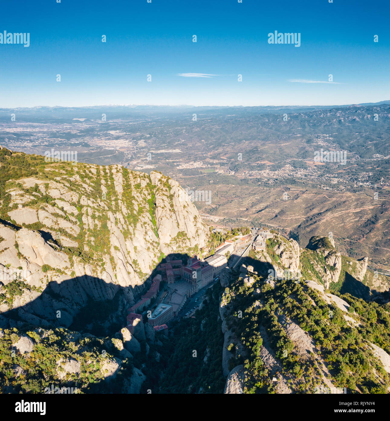 Aerial; panoramic view of famous mountain range, place of pilgrimage for many people; stone cliffs, ancient gothic architecture with modern transporta Stock Photo