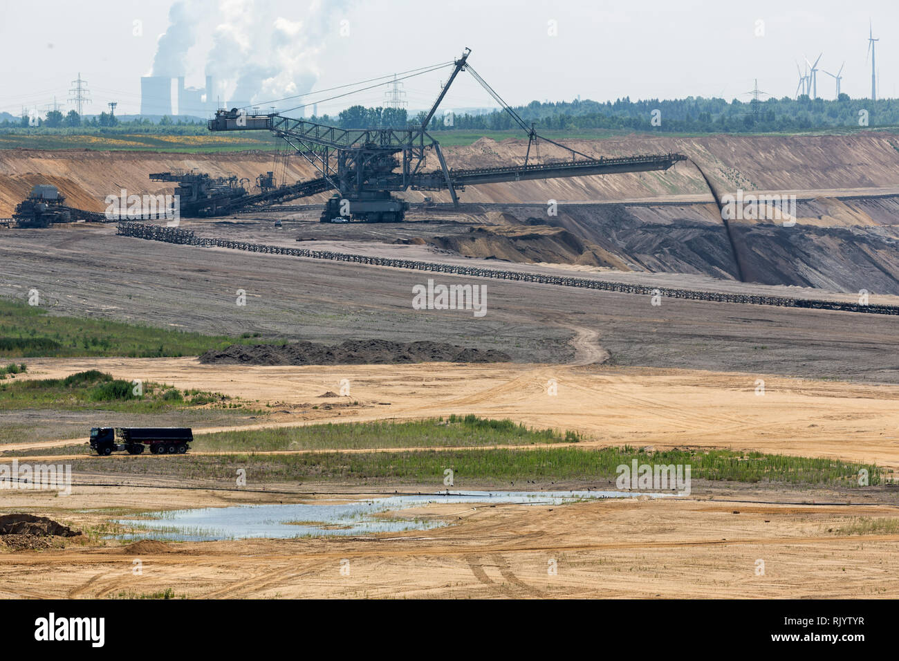 Brown coal open pit landscape with digging excavator in Germany Stock Photo