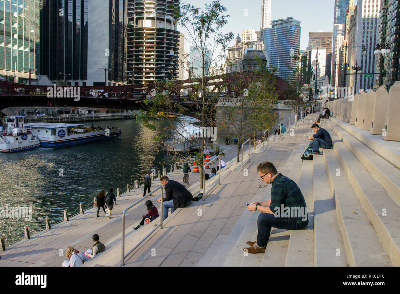 People engrossed in their cell phones. Chicago Riverwalk. Stock Photo