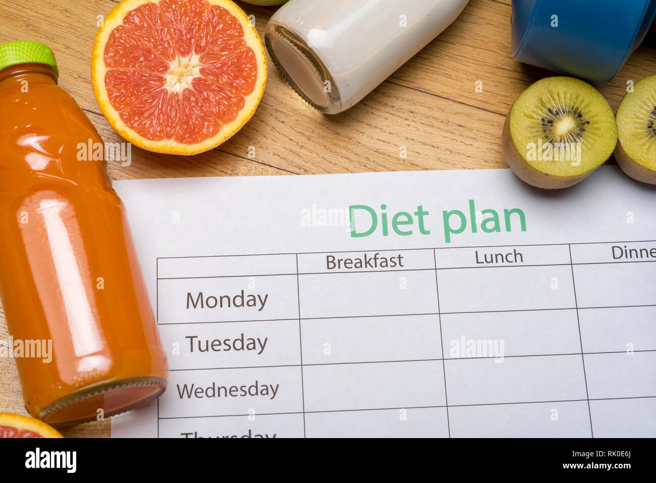 Diet plan, tape measure, water, diet of fresh fruits on the wooden floor. weight loss and ...