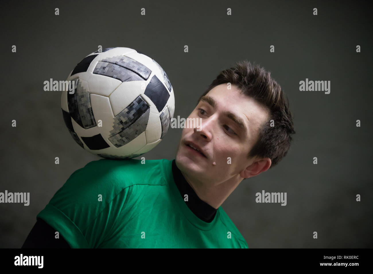 Football concept. Soccer player balancing a ball on his shoulder