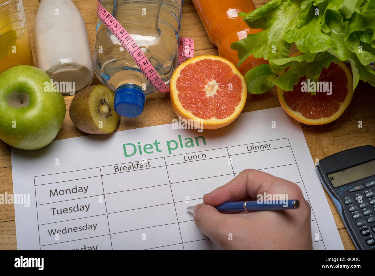 Diet plan, tape measure, water, diet of fresh fruits on the wooden floor. weight loss and ...