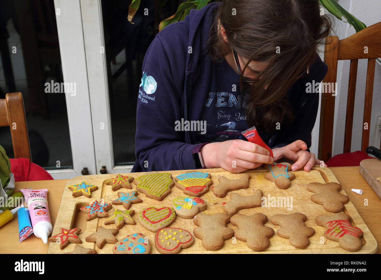 Thirteen Year Old Girl Decorating Christmas Cookies Surrey England Stock Photo