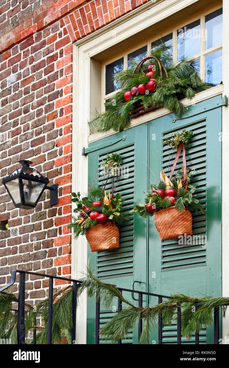 Christmas decorations; double green doors; transom; baskets; red apples; greens; holiday; festive; colorful; lantern; Palmer House; 1754, Colonial Wil Stock Photo